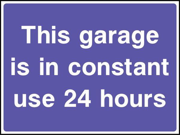 This garage is in constant use 24 hours road sign